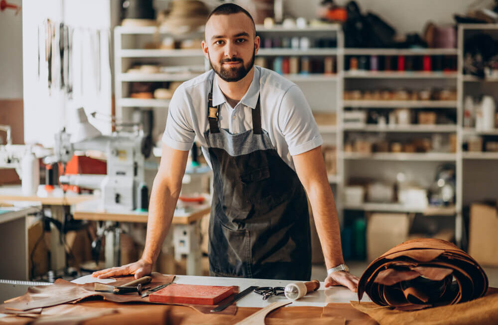 Agência Simi designer-e-alfaiate-de-couro-trabalhando-em-uma-fabrica