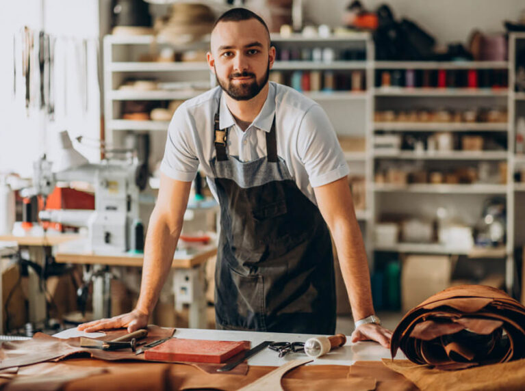 Agência Simi designer-e-alfaiate-de-couro-trabalhando-em-uma-fabrica