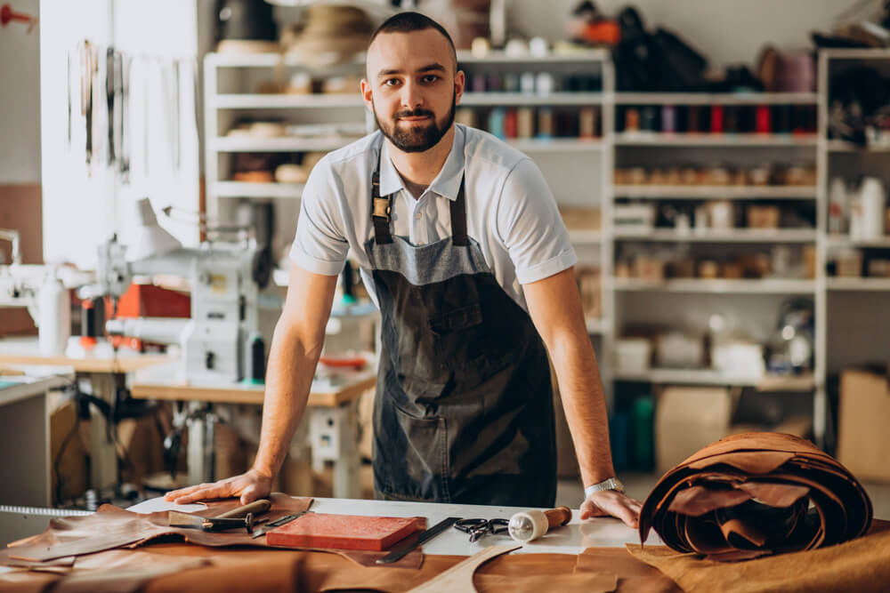 Agência Simi designer-e-alfaiate-de-couro-trabalhando-em-uma-fabrica