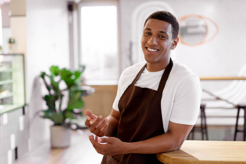 homem-sorridente-de-tiro-medio-com-avental agencia simi